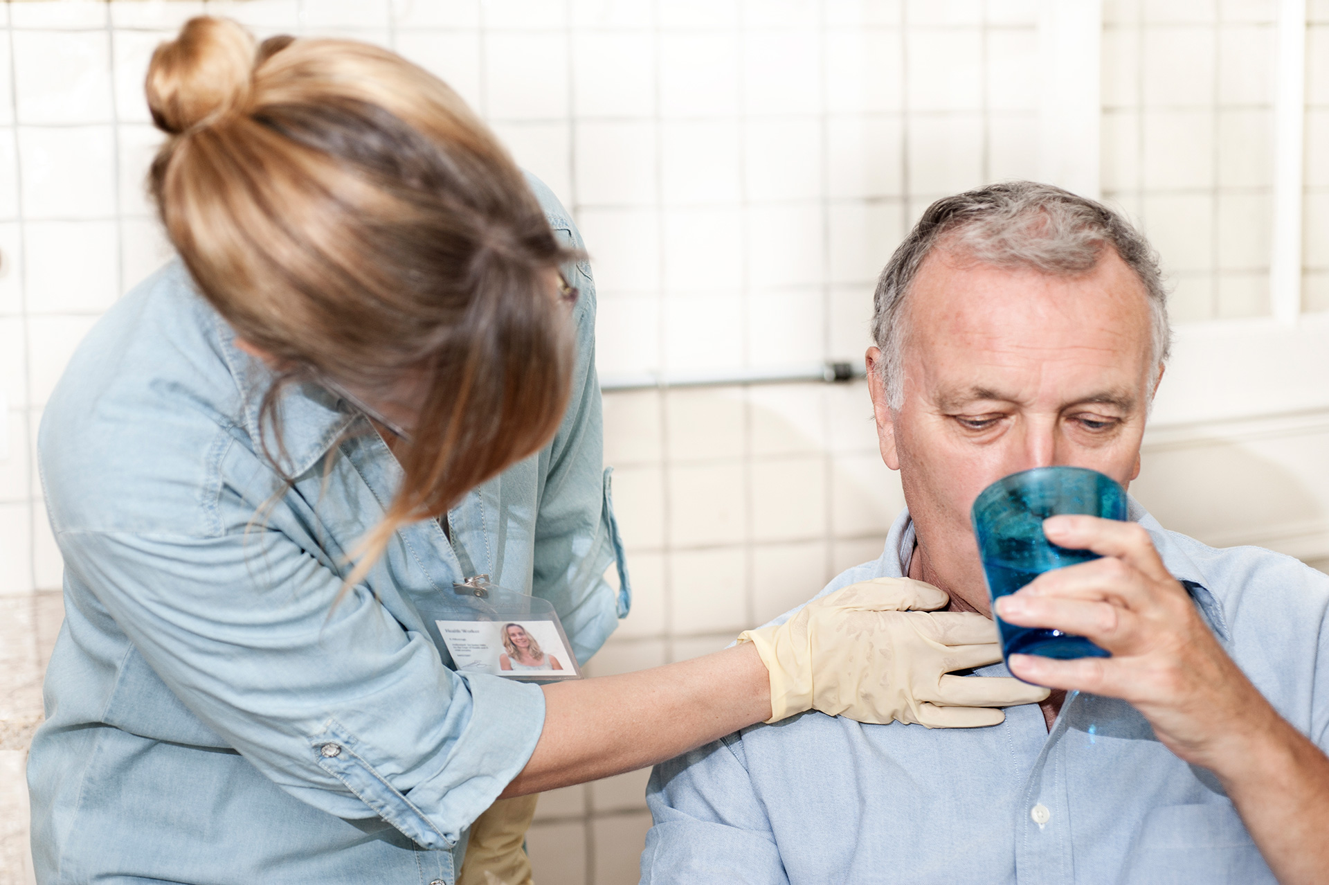 Personal de enfermería atendiendo a un paciente que bebe agua