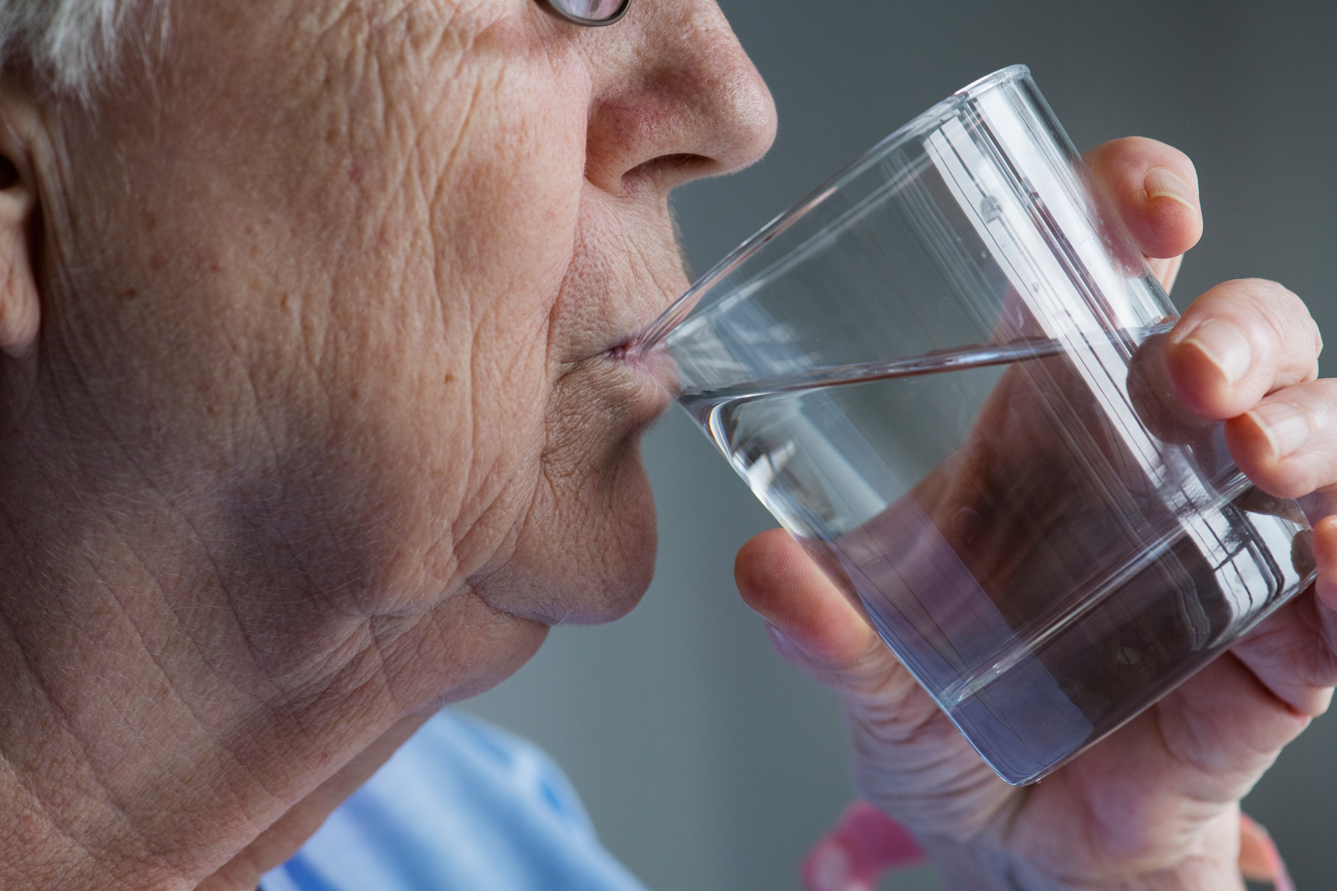 Paciente anciano bebiendo agua