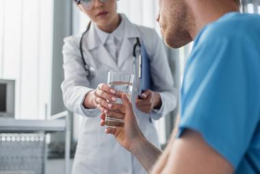 Nurse assisting patient drinking water